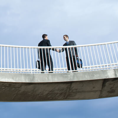 Men on bridge shaking hands