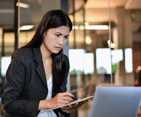 woman at laptop with notes